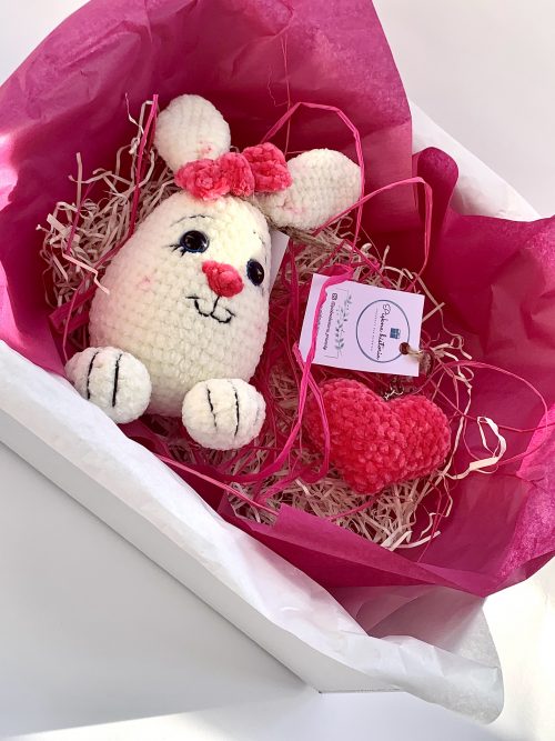 prezent z szydełkowym królikiem i breloczkiem na różowym tle